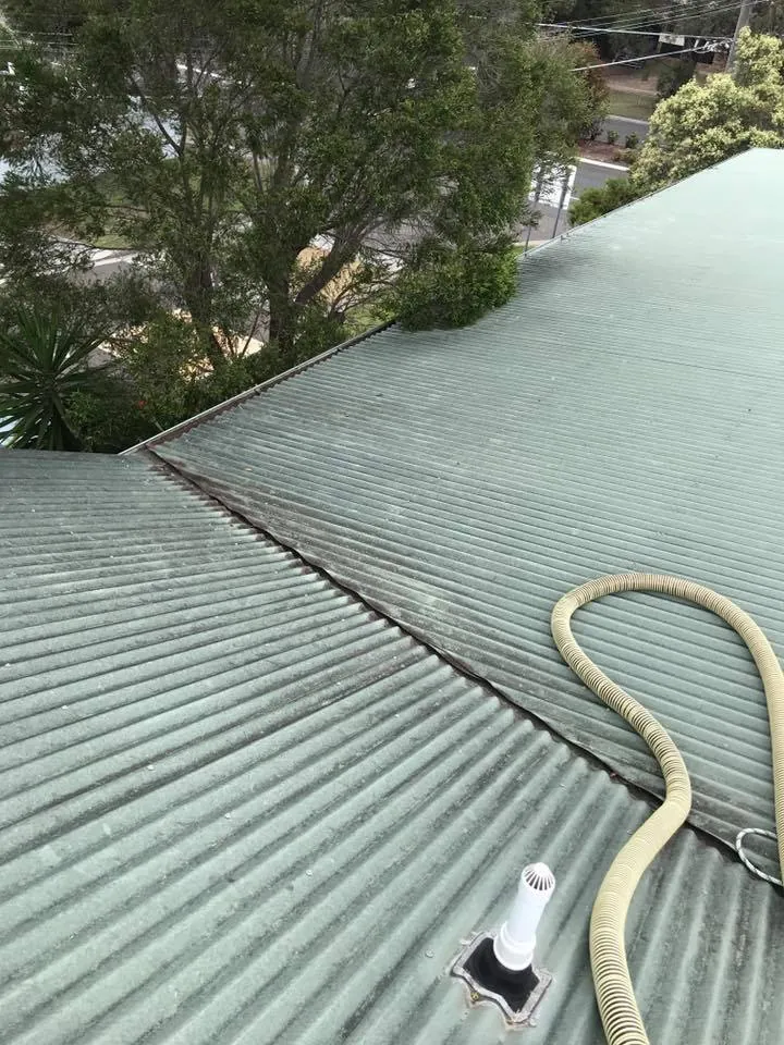 The same roof valley after cleaning, our vacuum hose on the roof beside it